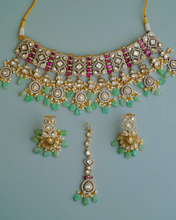 Ornate necklace with matching earrings on a light blue background